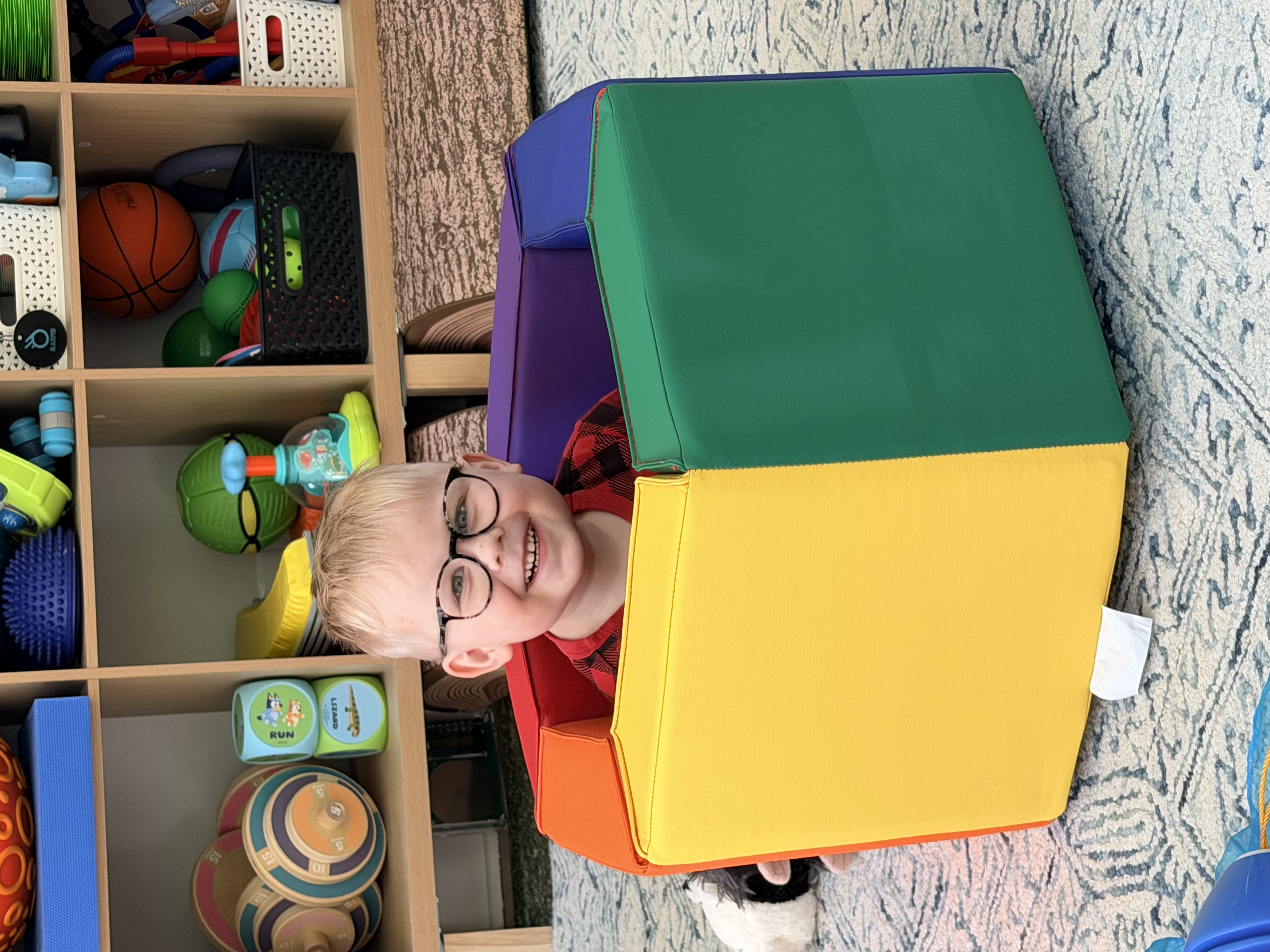 Felix smiling inside a colorful foam play set